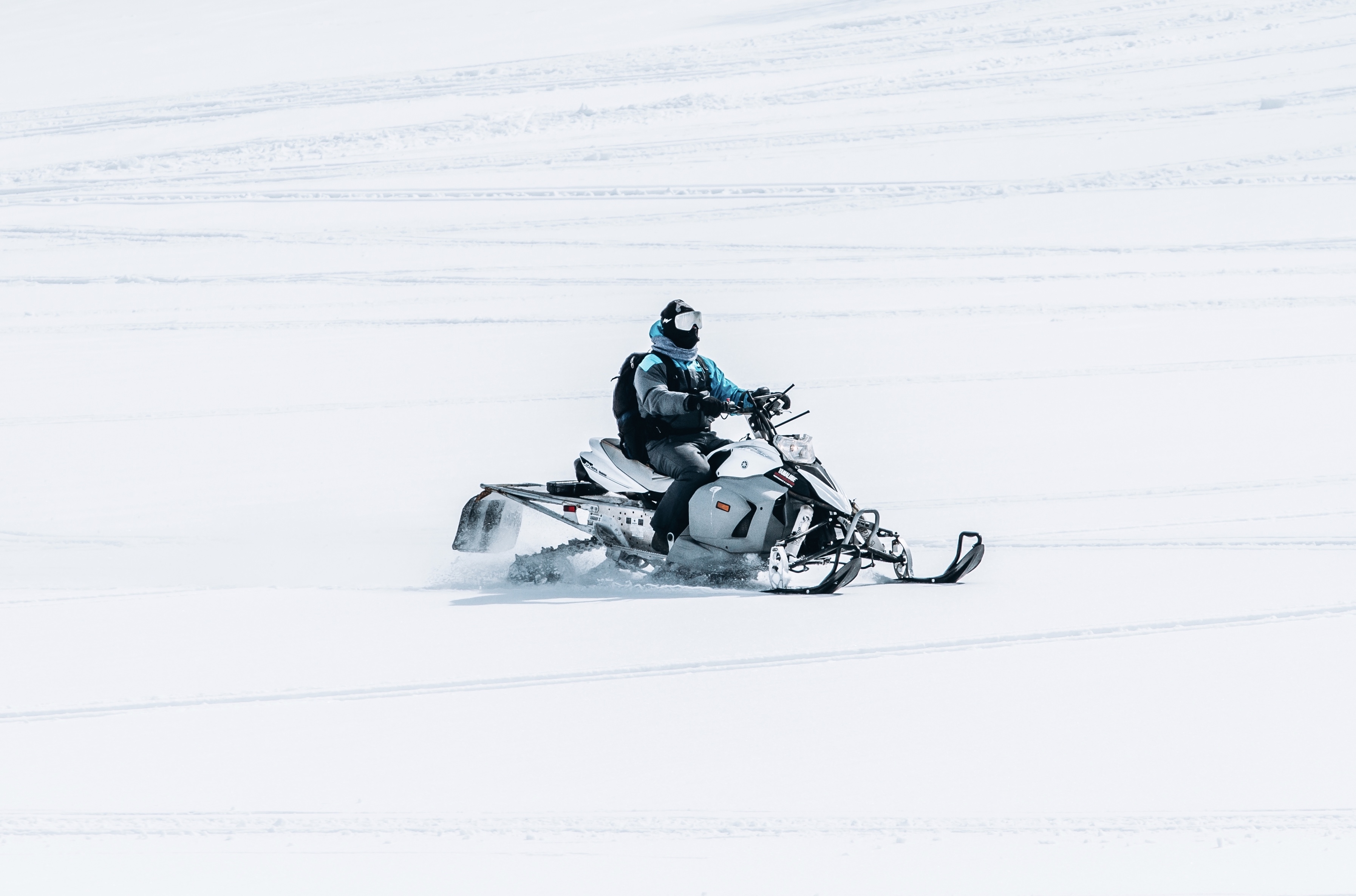 male-riding-snowmobile-large-snowy-field.jpg